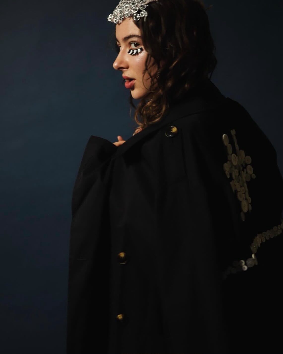 COTTONSON editorial portrait: model in a black embroidered coat with a jeweled headpiece
